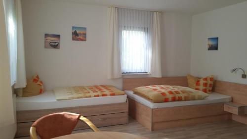 een slaapkamer met 2 bedden en een raam bij Apartmenthaus Zwenkau in Zwenkau