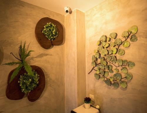 a bathroom with three potted plants on the wall at My Sj Hotel in Subang Jaya
