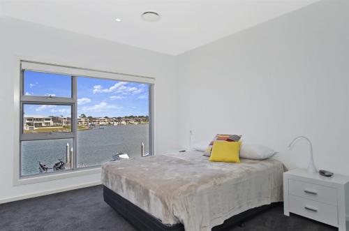 a bedroom with a bed and a large window at 484 The Anchorage Port Macquarie in Port Macquarie