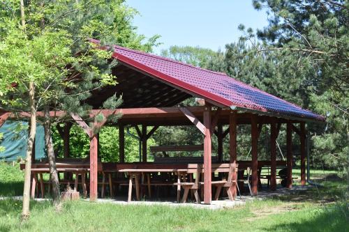 a pavilion with a red roof on top of it at Newland Wójtowicz in Debrznica