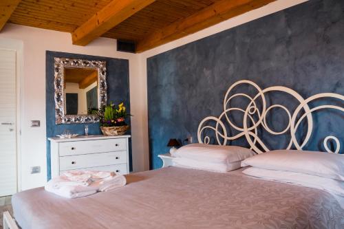 a bedroom with a large bed and a mirror at Ca' Baetti l'Antica Corte in Roncola