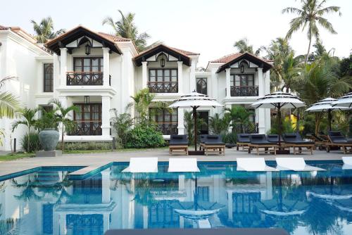 a resort with a swimming pool with chairs and umbrellas at Andores Resort And Spa - Calangute in Calangute
