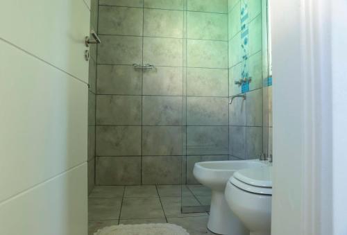 a bathroom with a shower and a toilet and a sink at Terralagum in Villa Parque Siquiman