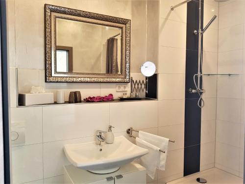 un bagno con lavandino e specchio di Hotel Schützen a Rastatt