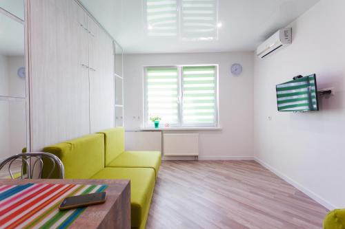 a living room with a yellow couch and a table at Modern Studio Apartments in Kyiv