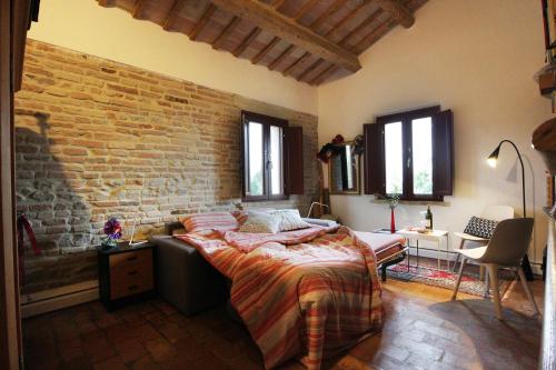 um quarto com uma cama e uma parede de tijolos em quindici alberi em Serra deʼ Conti