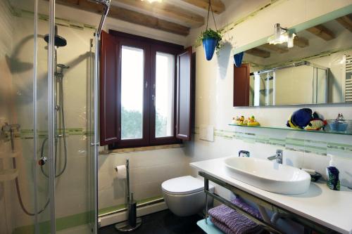 La salle de bains est pourvue d'un lavabo, d'une douche et de toilettes. dans l'établissement quindici alberi, à Serra deʼ Conti