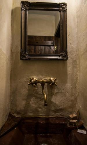 a bathroom with a mirror and a sink at Montanema Handmade Village in Platanákos