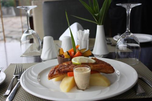 a plate of food with meat and vegetables on a table at Pullman Lubumbashi Grand Karavia. in Lubumbashi