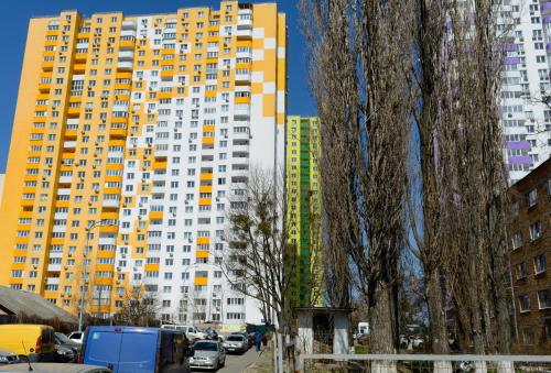 a large yellow and white building in a city at Комфортні мині-апартаменти студіо на Юлії Здановської in Kyiv