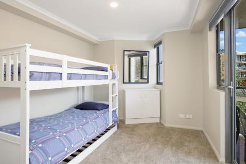 a bedroom with two bunk beds and a window at Flightdeck 301 5-7 Clarence Street in Port Macquarie