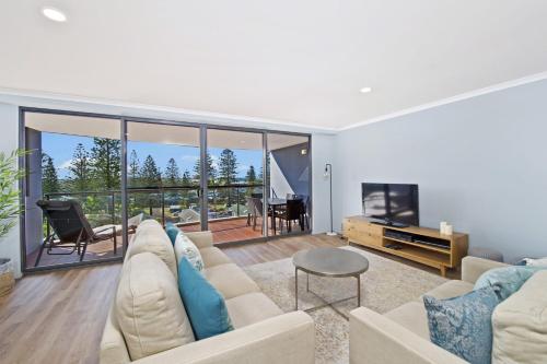 a living room with a couch and a television at Flightdeck 301 5-7 Clarence Street in Port Macquarie