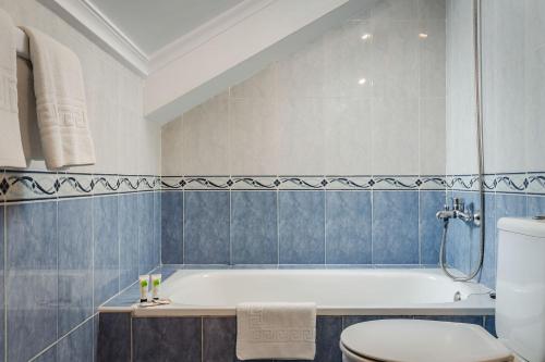 a bathroom with a white tub and a toilet at Hotel Surfances in Suances