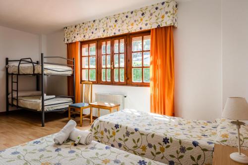 een slaapkamer met 2 bedden en een stapelbed bij Hotel Surfances in Suances