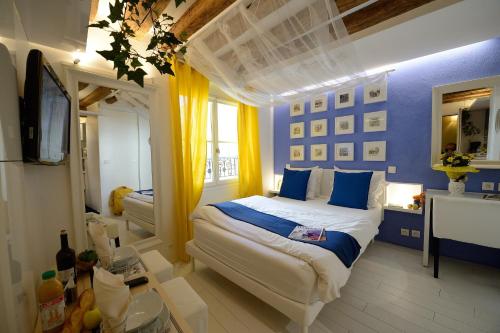 - une chambre avec un lit blanc et des murs bleus dans l'établissement Les Patios du Marais 2, à Paris