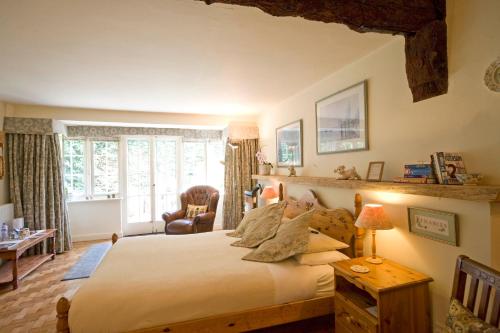 a bedroom with a large bed and a chair at Park Cottage in Warwick