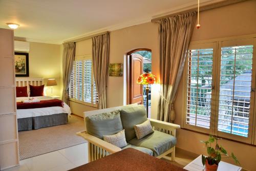 Bellgrove Guest House Sandton في جوهانسبرغ: غرفة نوم بسرير وكرسي في غرفة