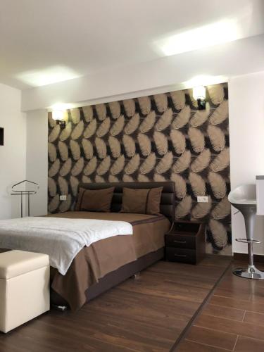 um quarto com uma cama grande e uma parede em Vlaicu Apartments em Constança