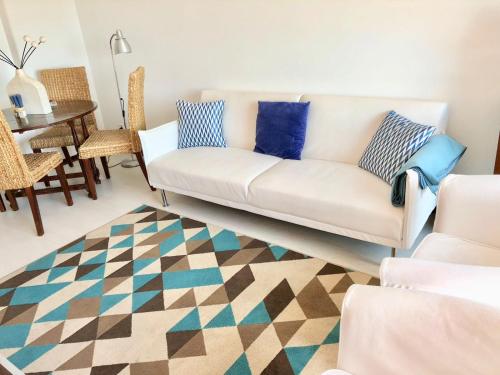 a living room with a white couch and a table at Estoril Beach Houses in Estoril