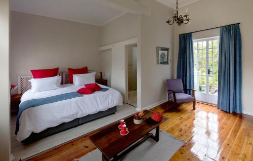 1 dormitorio con 1 cama grande con almohadas rojas en Seven Gables, en Port Elizabeth