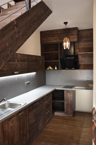 a kitchen with wooden cabinets and a sink at Penzion Víno Hruška Blatnička in Blatnička