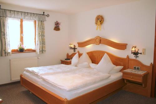 a bedroom with a large bed with a wooden headboard at Gästehaus Marianndl in Schönau am Königssee