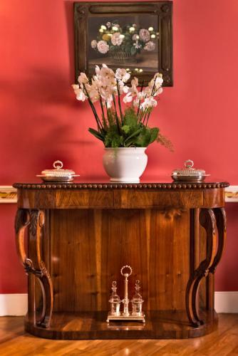 a table with a vase of flowers on top of it at Hotel Milton Rimini in Rimini