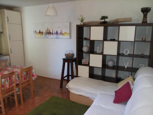 a living room with a white couch and a shelf at Sonce in Izola