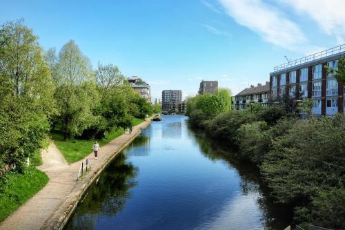 a river with a person walking on the side of it at Boutique Home from Home in London