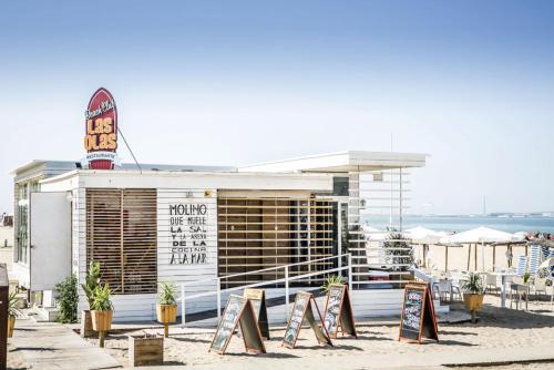 a building on the beach with signs in front of it at Apartamento en la playa de Valdelagrana in El Puerto de Santa María