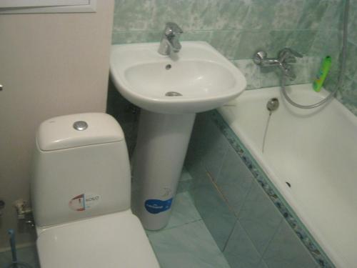 ein kleines Bad mit einem Waschbecken, einem WC und einem Waschbecken in der Unterkunft Apartment on Livoberezna metro station in Kiew