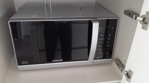 a microwave oven with a persons reflection in it at Charme Lake Loft in Ispra
