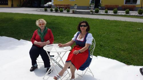 two women sitting at a table in a yard at Hütte zum Verlieben in Gurk