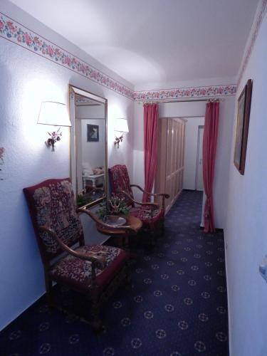 a hotel room with two chairs and a mirror at "Rheinschlosschen" Villa am Meer in Göhren