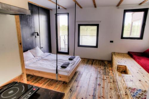 a room with a bed with a glass wall at ArkaBarka 2- Floating Dream Rooms and Apartments in Belgrade