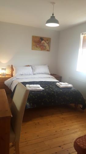 een slaapkamer met een bed, een tafel en een lamp bij Spindrift in Moville