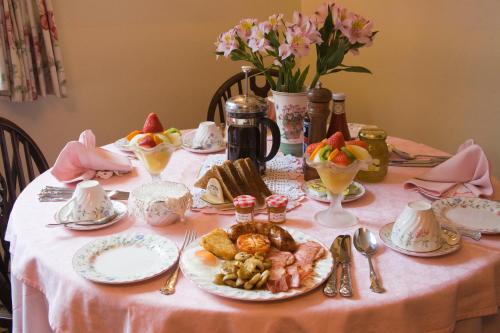 a table with a pink table cloth with food on it at Park Cottage in Warwick