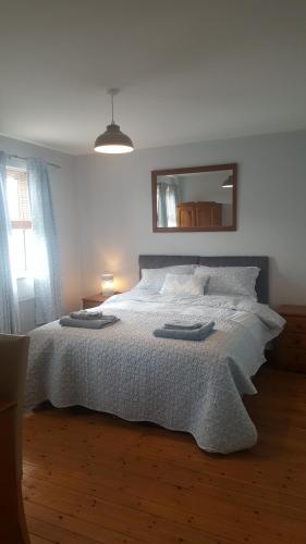 a bedroom with a large bed with two towels on it at Spindrift in Moville