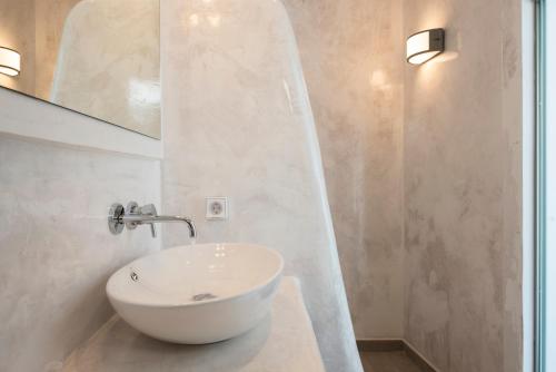 a bathroom with a white sink and a mirror at Villa Galinia in Akrotiri