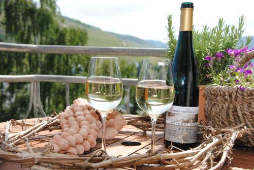 two glasses of white wine and a basket of grapes at Landhaus Kuntz in Lieser