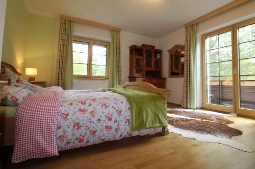 a bedroom with a bed with a red and green blanket at HAUS LÄRCHEGG Wellness Apartments in Bad Kleinkirchheim