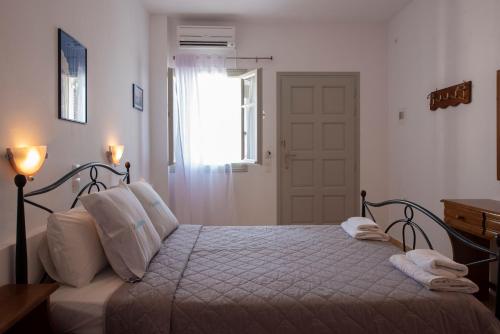 a bedroom with a bed with white sheets and a window at Villa Galinia in Akrotiri
