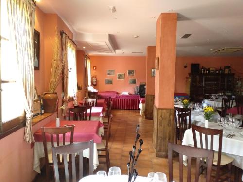 a restaurant with tables and chairs in a room at Hotel Rural Carlos I in Garganta la Olla