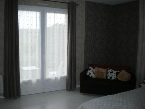 a bedroom with a bed and a sliding glass door at La clé des champs in Largillay