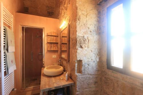 a stone bathroom with a sink and a shower at Masseria Fano Relais & Wine in Salve