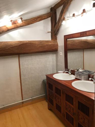 uma casa de banho com 2 lavatórios e um espelho em Maison de charme em Concourson-sur-Layon