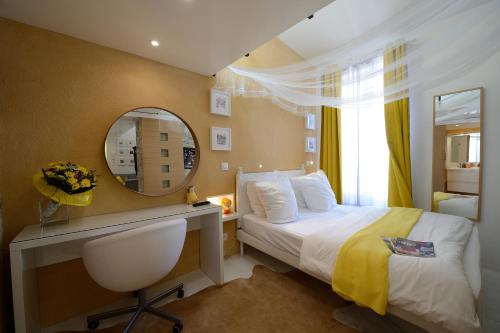 a bedroom with a bed and a mirror and a desk at Les Patios du Marais 1 in Paris