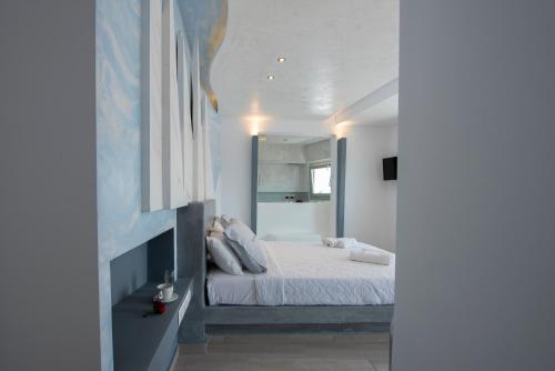 a white bedroom with a bed and a mirror at Villa Galinia in Akrotiri