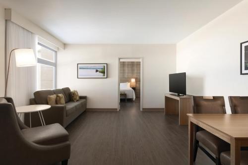 a living room with a couch and a television at Radisson Kingswood Hotel & Suites, Fredericton in Fredericton