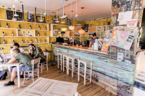 a group of people sitting at tables in a restaurant at ArkaBarka 2- Floating Dream Rooms and Apartments in Belgrade